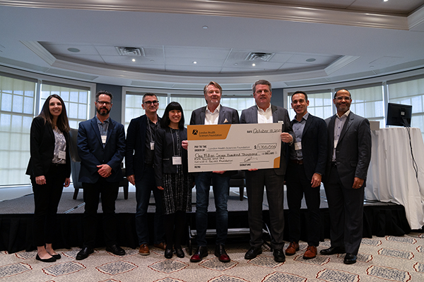 Kirk and Joanne Baines hold a giant cheque with doctors and LHSF CEO